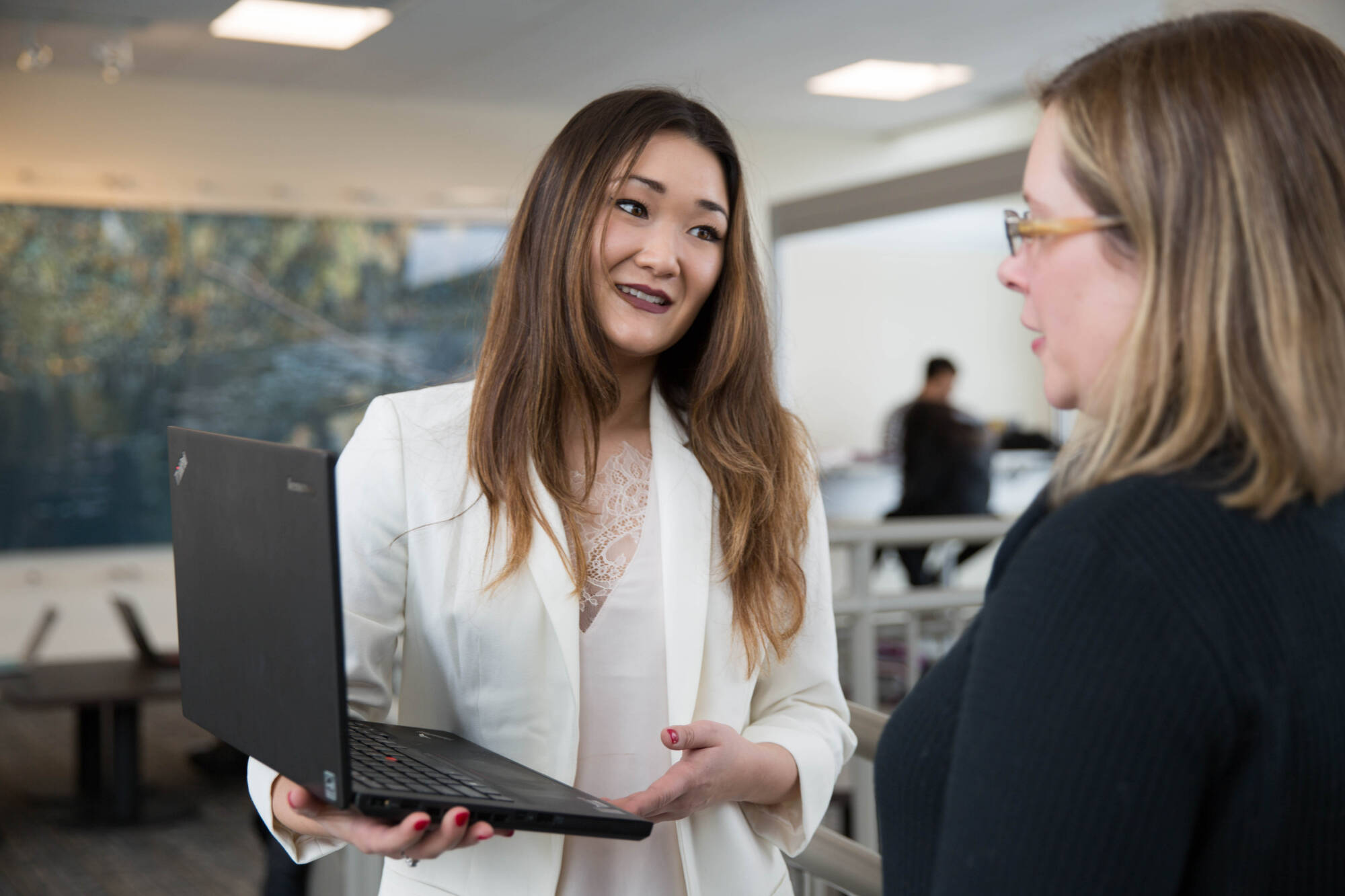 Student and faculty member work on laptop together